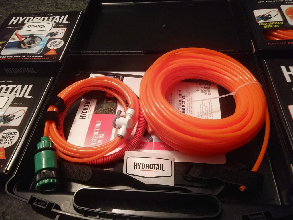 Orange hydrotail hoses in a black case with packaging in the background
